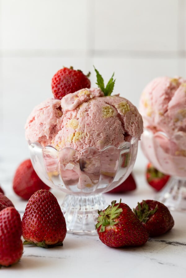 Strawberry Shortcake Ice Cream scooped into a glass ice cream dish.