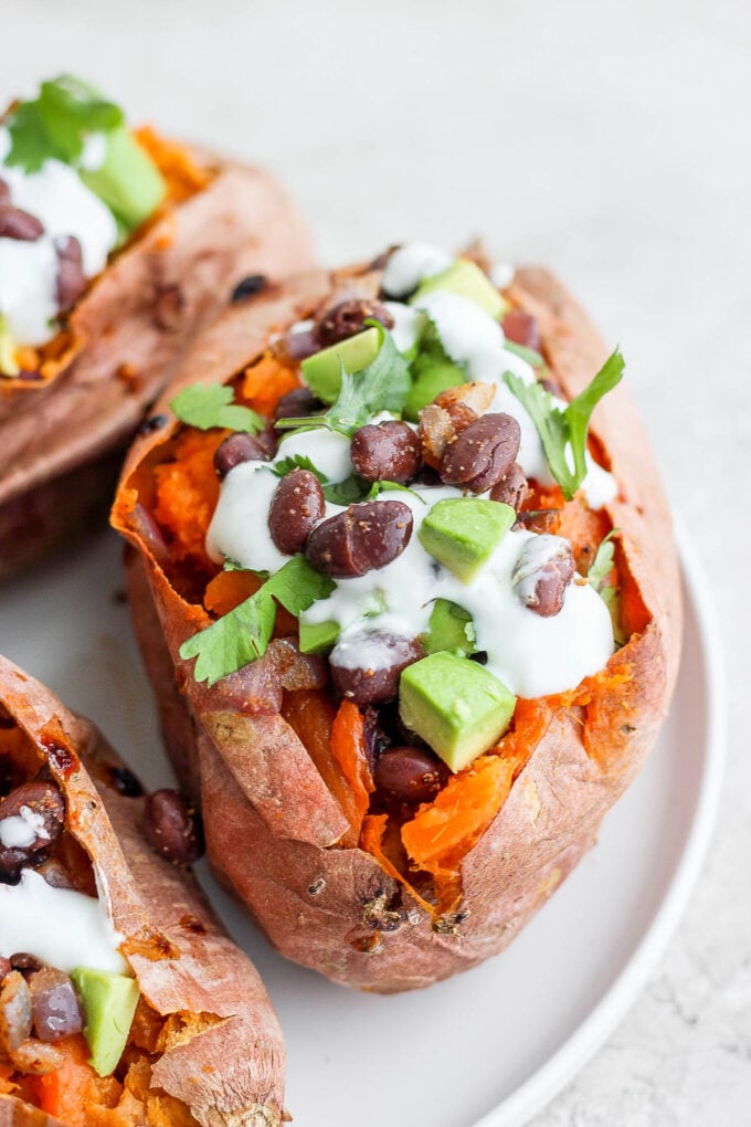 sweet potatoes stuffed with black beans, and avocado and topped with crema