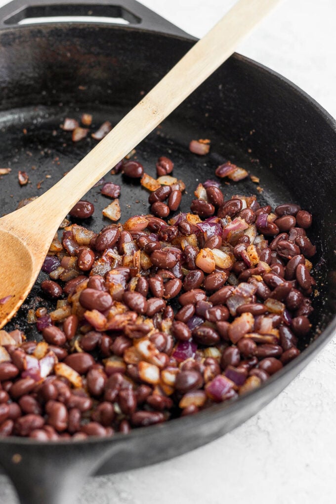 sauteed black beans and onion in a skillet