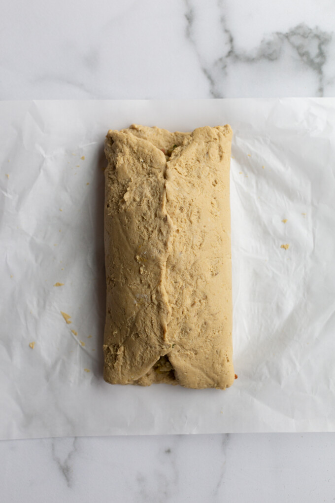 how to make a seitan roast: seitan folded up a piece of parchment paper