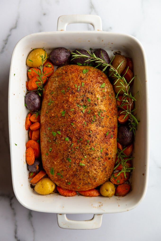 stuffed vegan roast surrounded by roasted veggies on a platter