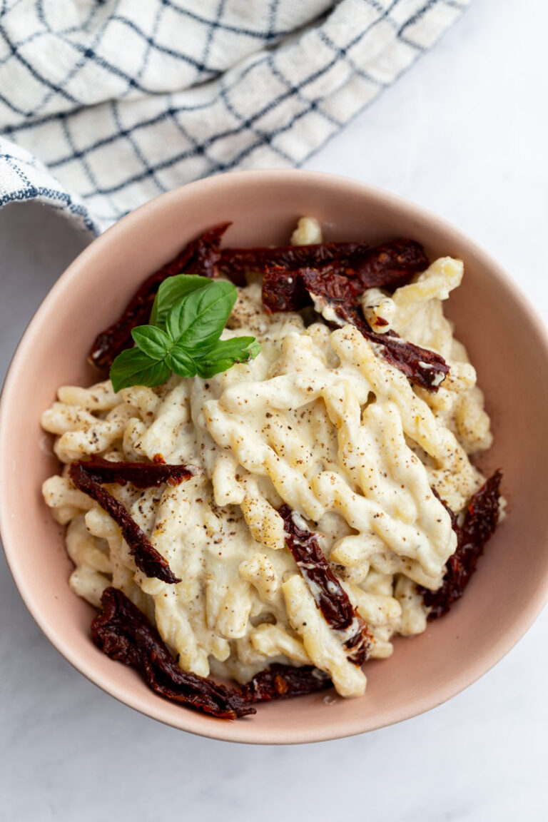 spiral pasta with creamy white sauce and topped with sun dried tomatoes