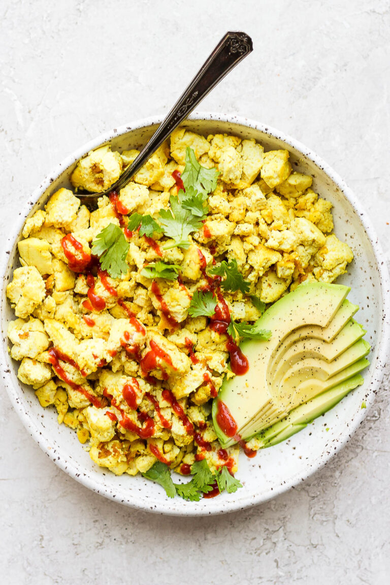 Tofu scramble topped with ketchup and served with avocado.