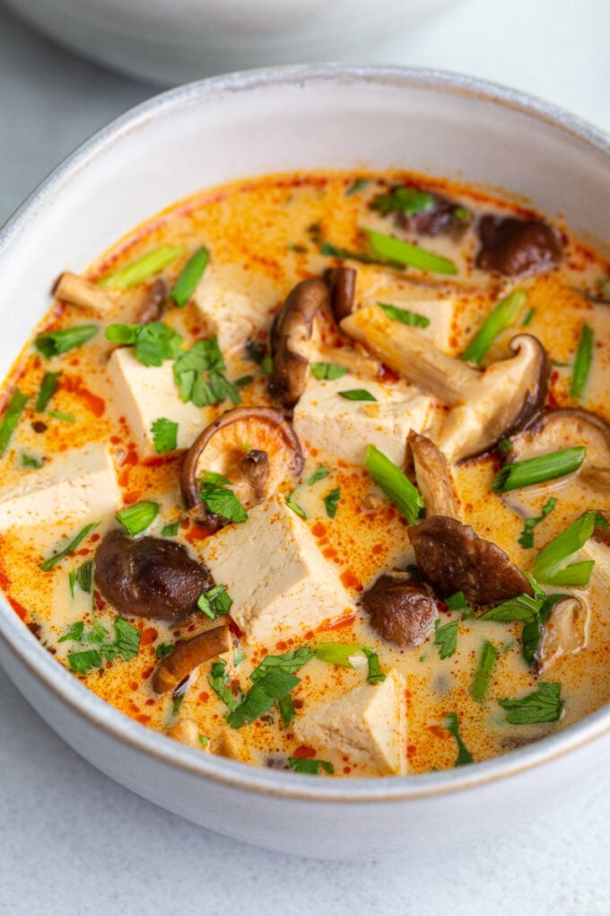 Coconut tofu soup topped with a garnish of fresh cilantro and green onions.