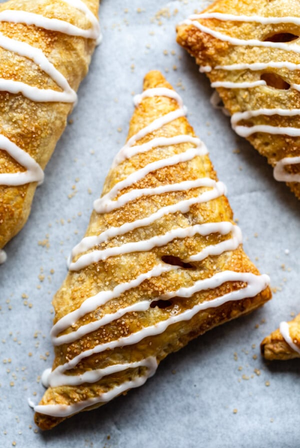 vegan apple turnovers covered with a drizzle of icing