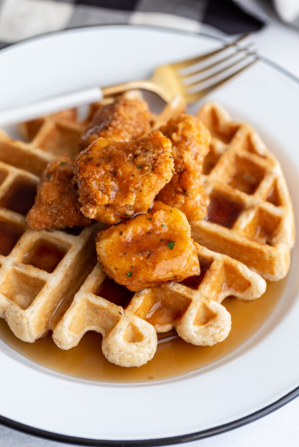 waffle on a white plate topped with vegan chicken nuggets