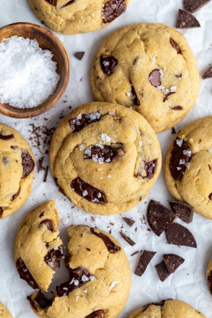 Vegan chocolate chip cookies stacked on top of each other and topped with a bit of flaky sea salt