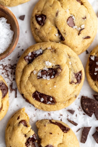 Vegan chocolate chip cookies stacked on top of each other and topped with a bit of flaky sea salt