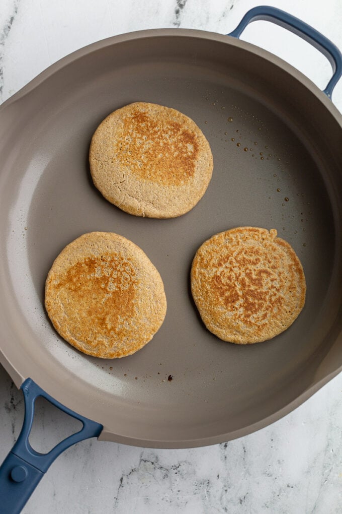 3 browned oat pancakes in a large skillet