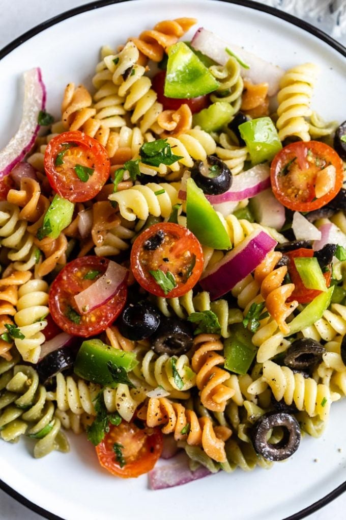 close up shot of pasta salad with tri color past spirals and veggies