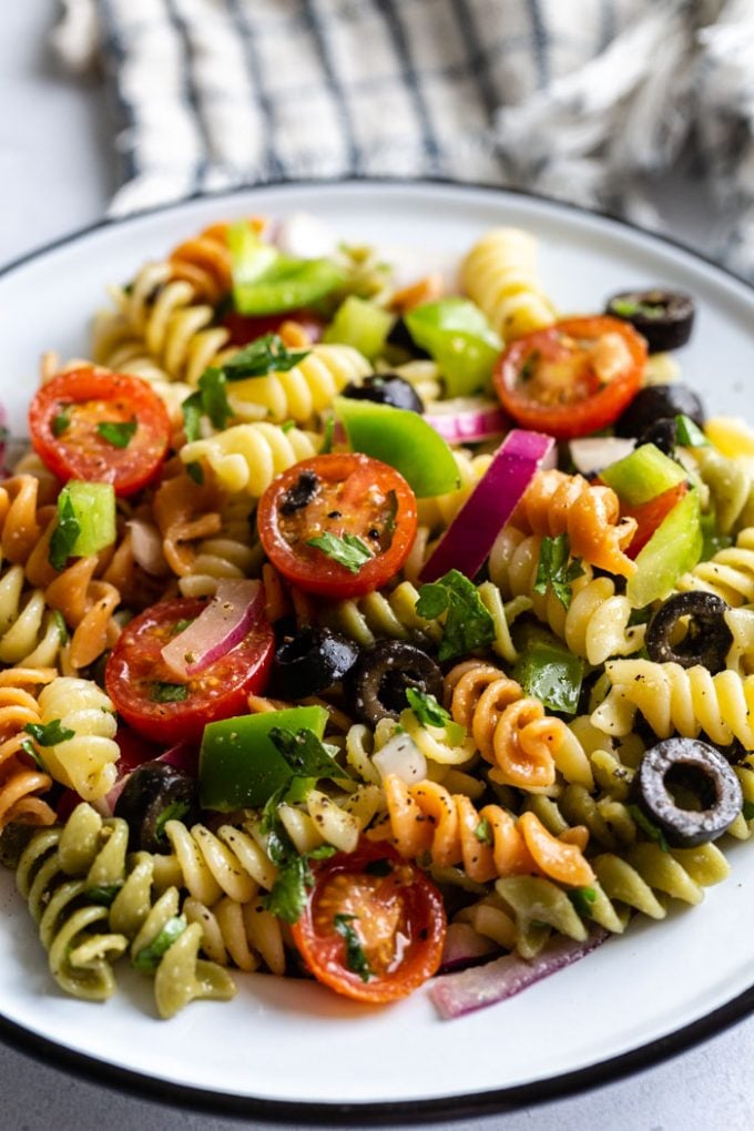 close up shot of pasta salad with tri color past spirals and veggies