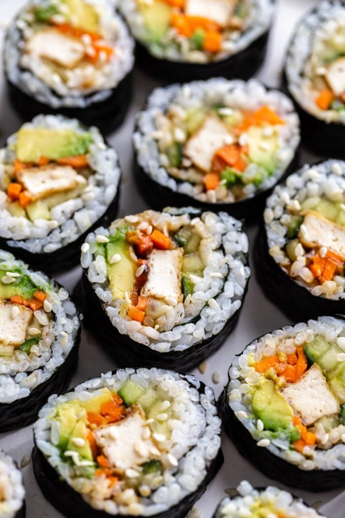 side shot of a plate of tofu sushi filled with tofu, carrots, avocado, and cucumber