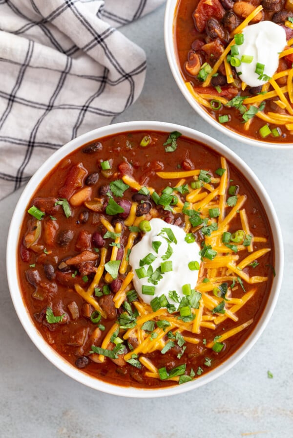 Instant pot chili topped with shredded cheese, sour cream and green onions.