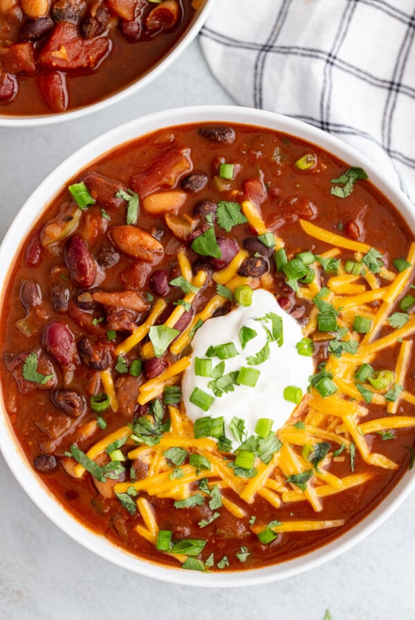 Vegan chili topped with sour cream and shredded cheese.