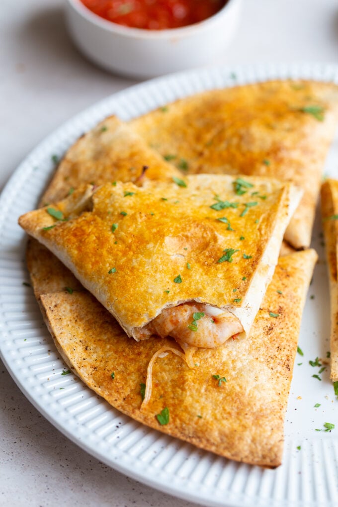 large pizza pockets made out of tortillas. one has a bite taken out and you can see the cheese oozing out