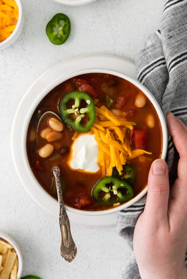 Vegetarian Taco Soup topped with sour cream, grated cheese and jalapeño slices