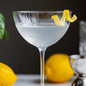 vesper cocktail in a cocktail glass with a lemon twist on the side