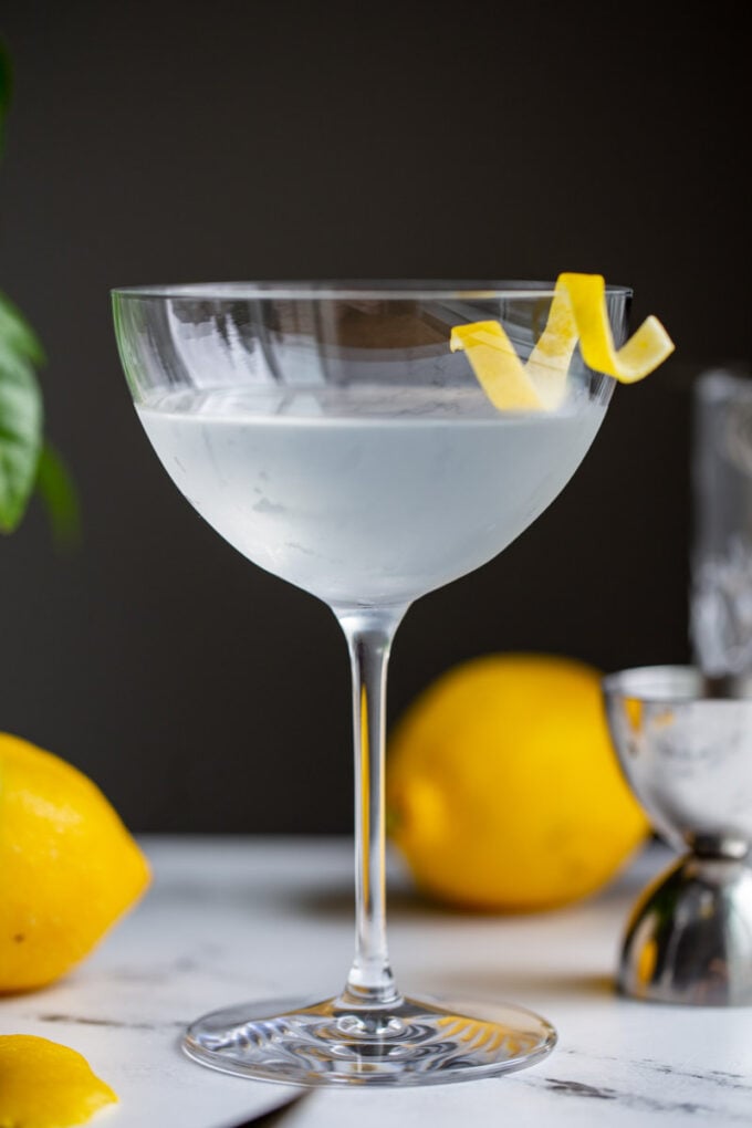 vesper cocktail in a cocktail glass with a lemon twist on the side