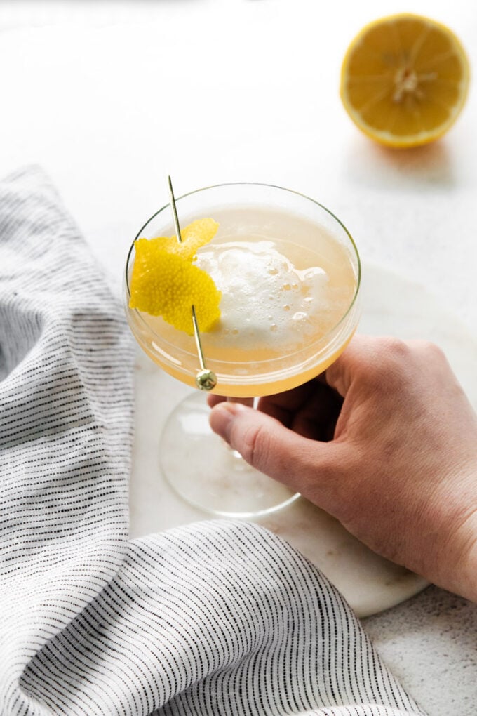 woman's hand holding a vodka sour cocktail