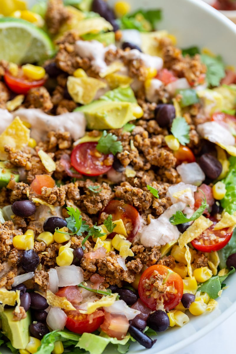 vegetarian taco salad loaded with lettuce, tomato, avocado, walnut meat, and a cream sauce