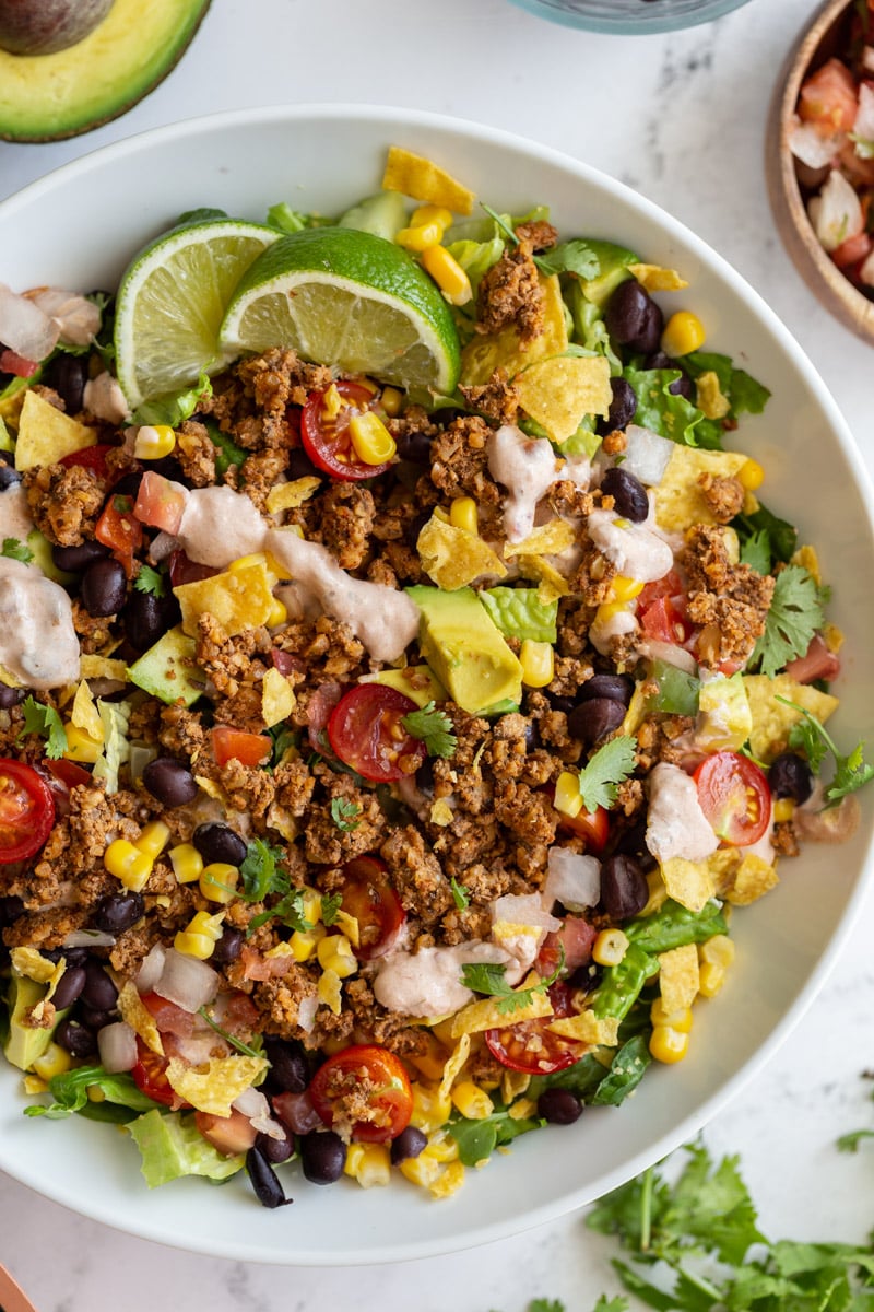 vegetarian taco salad loaded with lettuce, tomato, avocado, walnut meat, and a cream sauce