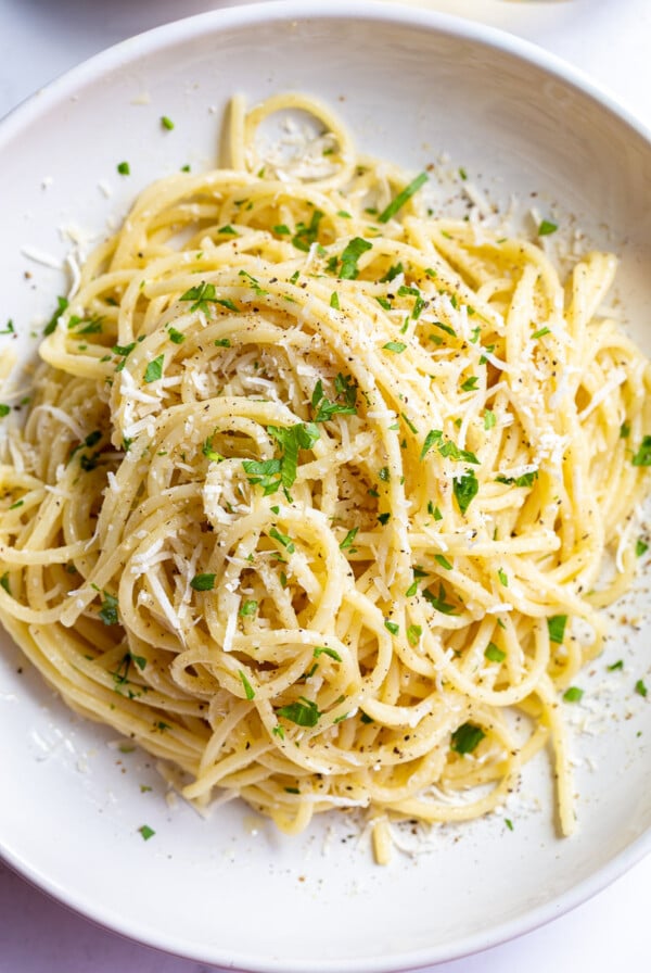 white wine pasta in a salad bowl topped with fresh herbs